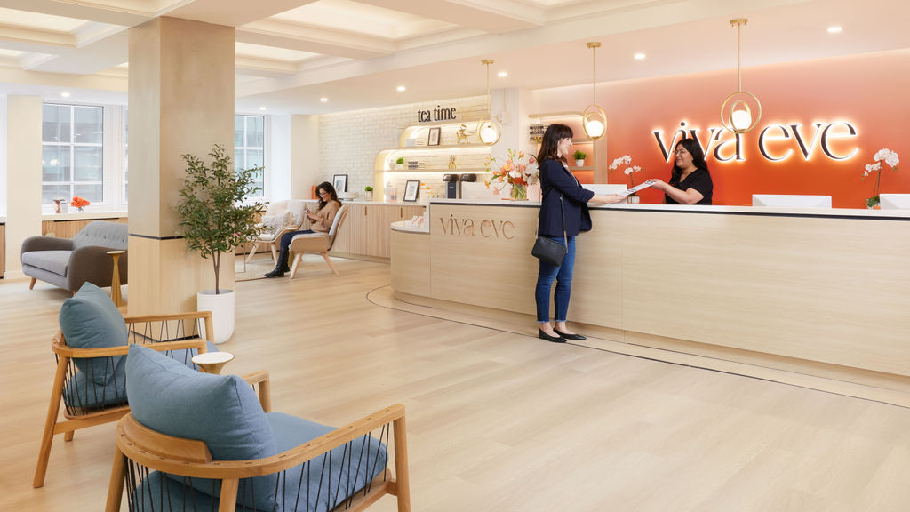 Viva Eve Manhattan office lobby and reception desk with lounge seating, tea station, and staff member assisting a patient